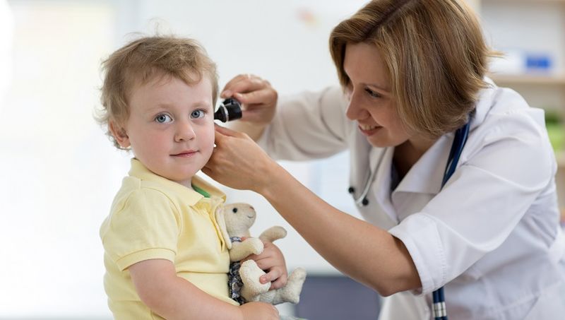 Ärztin untersucht Ohr eines Kindes